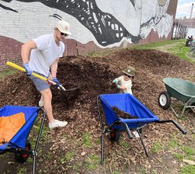 Father and son shovel mulch
